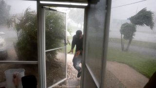 Chris Williams runs through a rain storm as he packs his car to evacuate his apartment before Hurricane Milton’s arrival on October 09, 2024, in Fort Myers, Florida. 