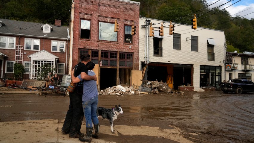 Resident Anne Schneider, right, hugs her friend Eddy Sampson as they survey damage left in the wake of Hurricane Helene, Tuesday, Oct. 1, 2024, in Marshall, N.C.