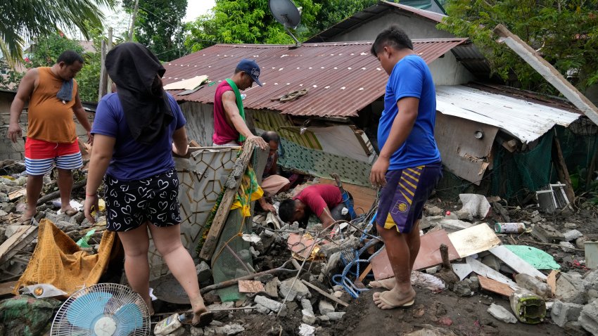 Residents try to recover personal belongings from their damaged home after a landslide triggered by Tropical Storm Trami recently struck Talisay, Batangas province, Philippines, Saturday, Oct. 26, 2024.