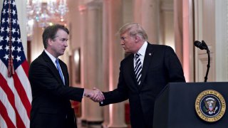 File – President Donald Trump, right, shakes hands with Brett Kavanaugh, associate justice of the U.S. Supreme Court, during a ceremonial swearing-in event in the East Room of the White House in Washington, D.C., U.S., on Monday, Oct. 8, 2018.