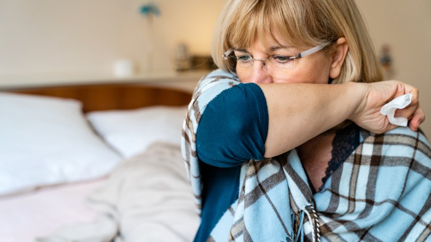 Senior Woman with Cough Sitting in Bed