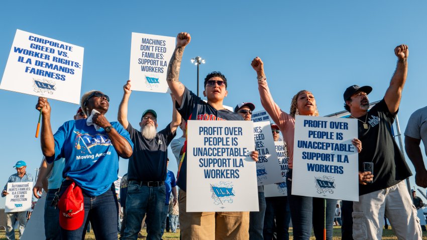 Dockworkers hold up picket signs