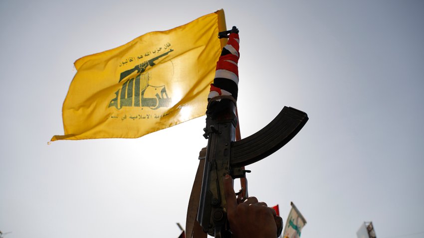 FILE - A Houthi supporter raises a Hezbollah flag during an anti-Israel and anti-U.S. rally in Sanaa, Yemen, Friday, Sept. 27, 2024.