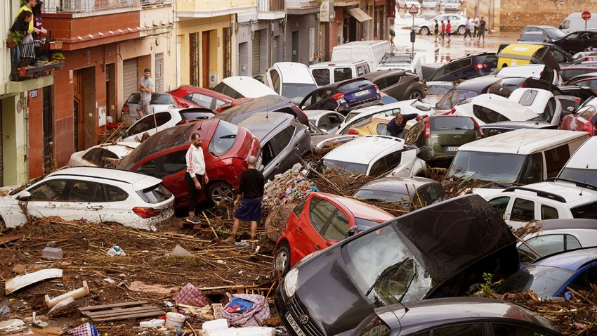 Residents look at cars piled up after being swept away by floods in Valencia, Spain, Wednesday, Oct. 30, 2024.