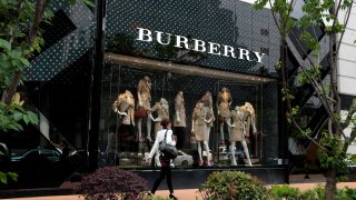 Shoppers walk past Burberry’s Shanghai store