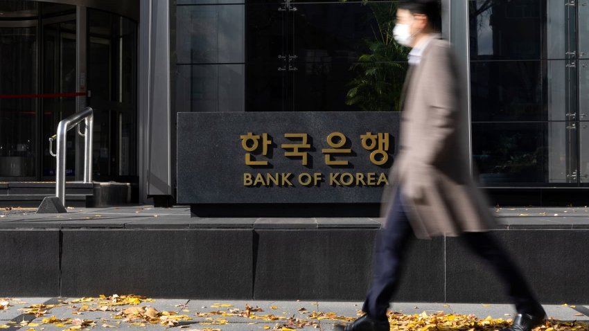 A pedestrian walks past signage for the Bank of Korea in Seoul, South Korea, on Monday, Nov. 22, 2021.