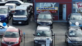 An advertisement for easy financing is posted on the front window of a used car lot on September 6, 2023 in San Pablo, California.