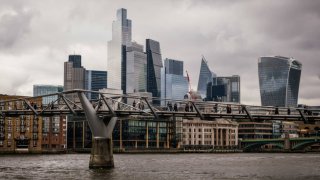 Commuters cross Millennium Bridge in view of skyscrapers on the skyline of the City of London, UK, on Tuesday, Oct. 29, 2024.