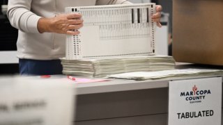 An election worker organizes tabulated cast ballots inside the Maricopa County Tabulation and Election Center on November 5, 2024 in Phoenix, Arizona. (