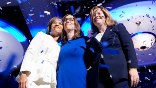 From left to right, Democratic Delaware Senate candidate state Rep. Lisa Blunt Rochester, Sarah McBride, Democratic candidate for Delaware’s at-large congressional district, and Lt. Gov. Elect Kyle Gay embrace on stage during an election night watch party Tuesday, Nov. 5, 2024, in Wilmington, Del.