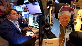 An image of President-elect Donald Trump is displayed as traders and financial professionals work on the floor of the New York Stock Exchange during the opening bell on Nov. 26, 2024.