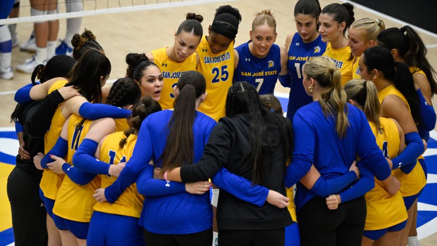 The San Jose State Spartans huddle on the court before an NCAA college volleyball match.