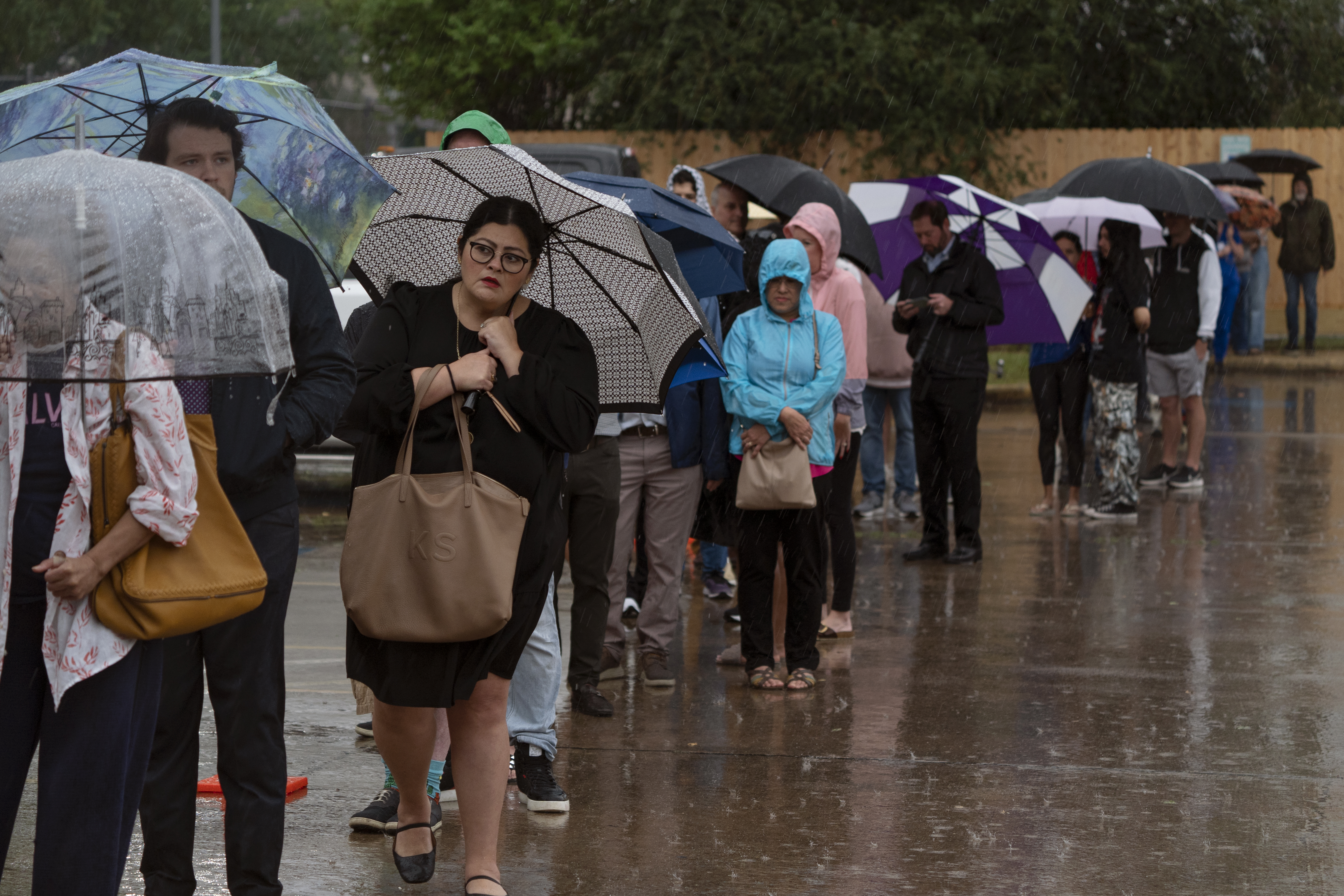 Despite heavy rain, people wait in line to vote at the Metropolitan Multi-Service Center on November 5, 2024 in Houston, Texas.