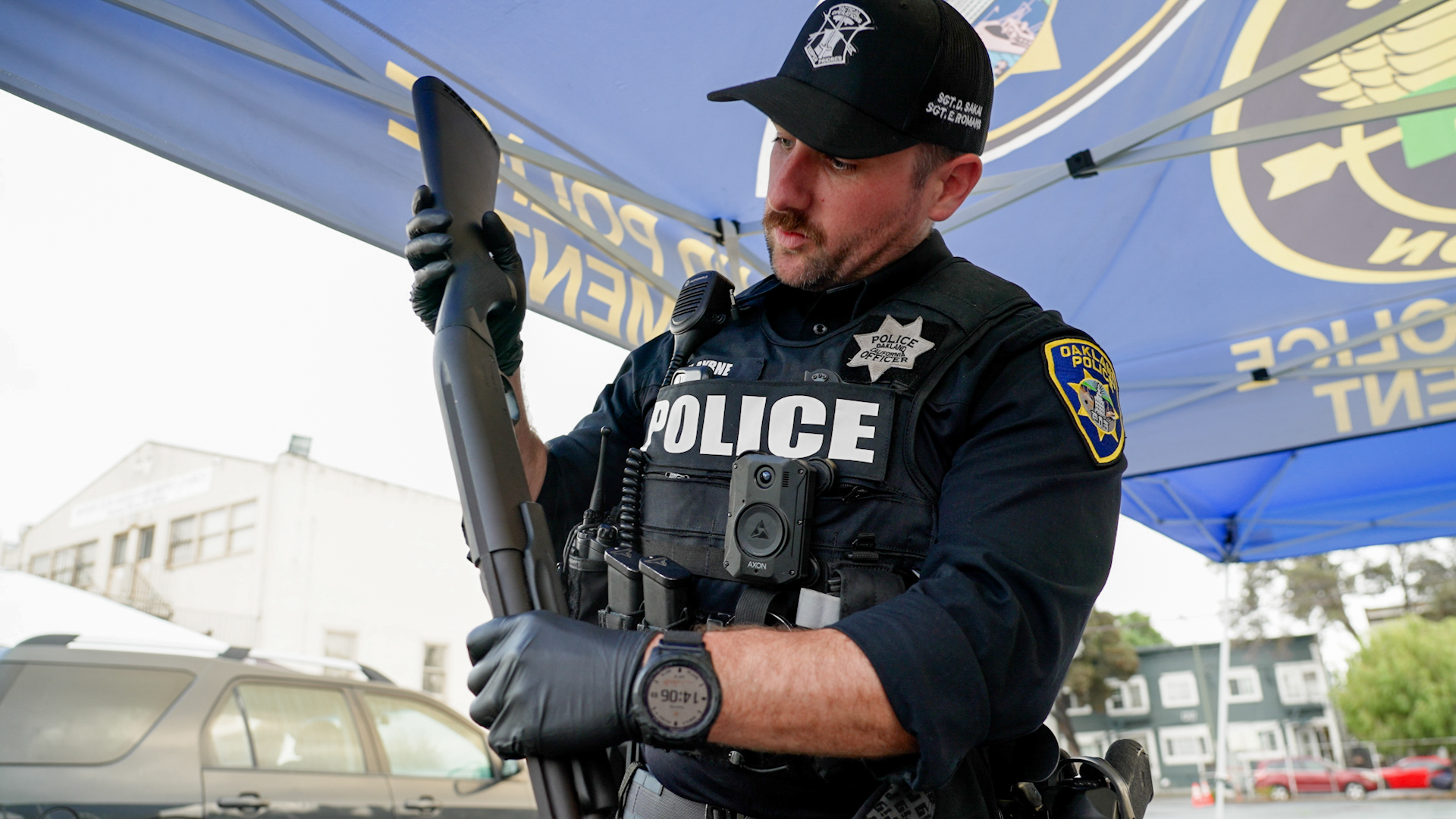 A police officer examines a long black gun