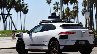 A Waymo autonomous self-driving Jaguar taxi drives along a street on March 14, 2024 in Los Angeles, California.