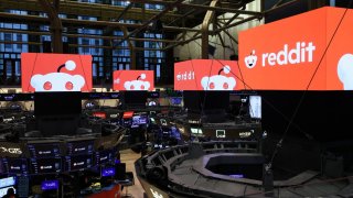 Traders work as Reddit’s logo is displayed at the New York Stock Exchange on March 21, 2024.