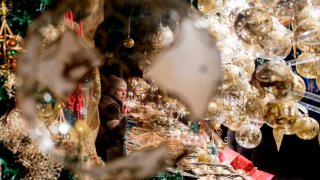 A visitor shops at a Christmas market in front of Vienna’s City Hall.