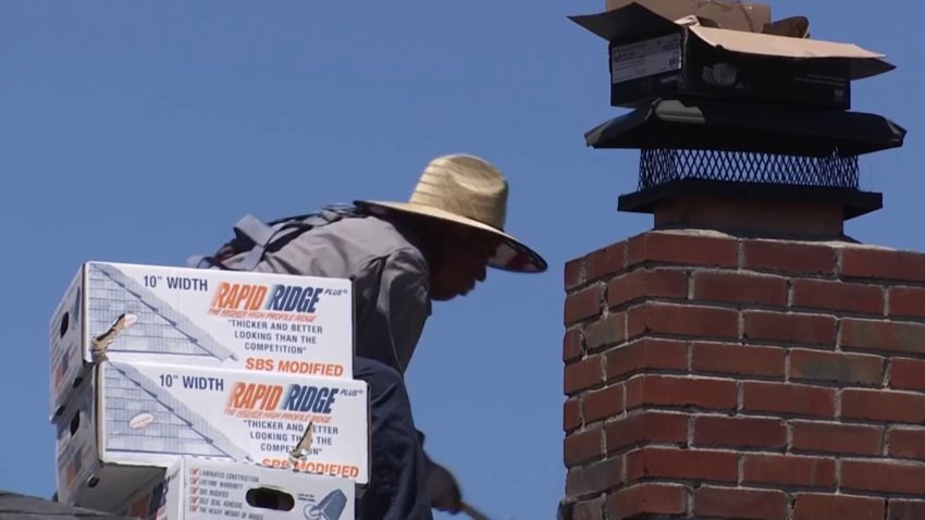 Roofer works on home