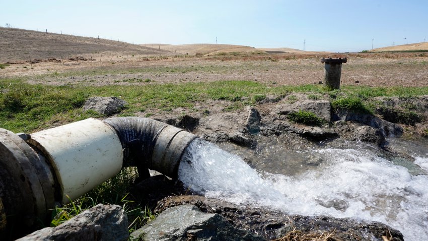 Well water flows from pumps into a canal that will be used to irrigate a vineyard, Monday, July 25, 2022, in Rio Vista, Calif.