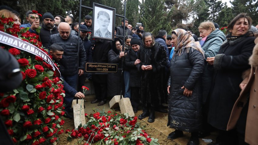 People mourn at the grave of flight attendant Hokume Aliyeva