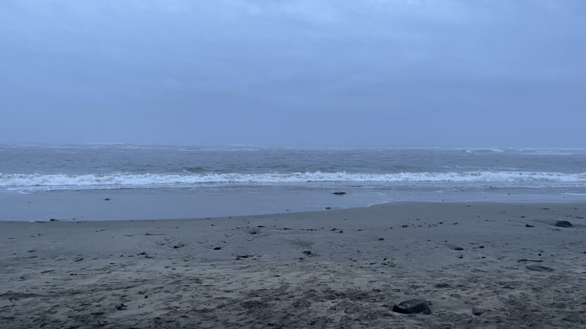 A beach on a cloudy day with high waves.