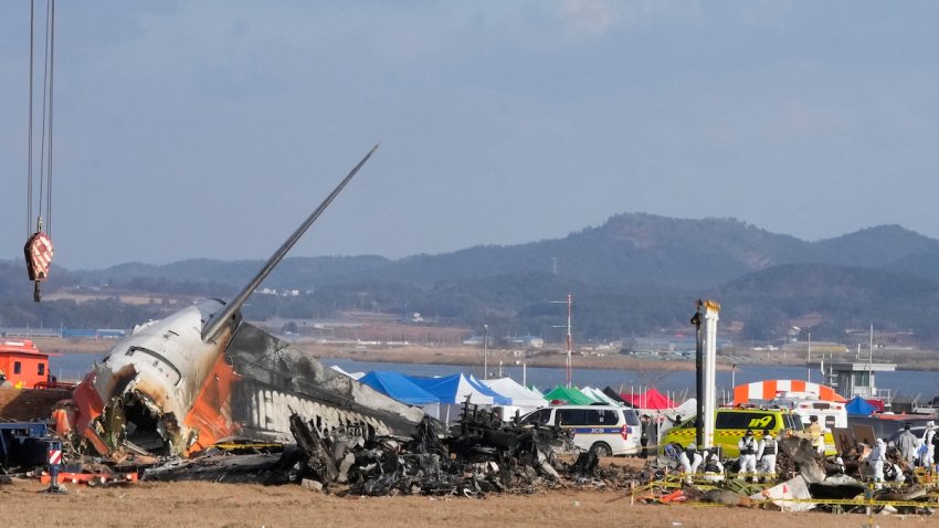 Rescue team members work at the site of a plane fire at Muan International Airport in Muan, South Korea, Monday, Dec. 30, 2024. (AP Photo/Ahn Young-joon)