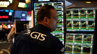 A trader works at his desk on the floor of the New York Stock Exchange (NYSE) during the first session of the new year on January 2, 2025, in New York City. 