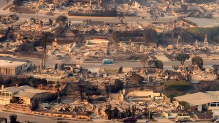 In this aerial view taken from a helicopter, burned homes are seen from above during the Palisades fire near the Pacific Palisades neighborhood of Los Angeles, California on January 9, 2025. 