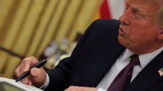 U.S. President Donald Trump signs documents as he issues executive orders in the Oval Office at the White House on Inauguration Day in Washington, U.S., Jan. 20, 2025.