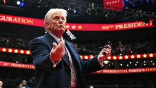 President Donald Trump throws pens to the crowd after signing executive orders during the inaugural parade inside Capital One Arena, in Washington, DC, on January 20, 2025.