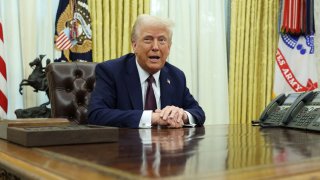 U.S. President Donald Trump sits in the Oval Office of the White House, as he signs executive orders, in Washington, U.S., Jan. 23, 2025.
