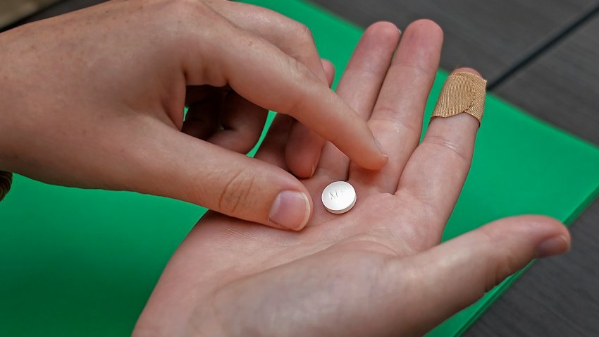 FILE – A patient prepares to take the first of two combination pills, mifepristone, for a medication abortion during a visit to a clinic in Kansas City, Kan., on, Oct. 12, 2022.