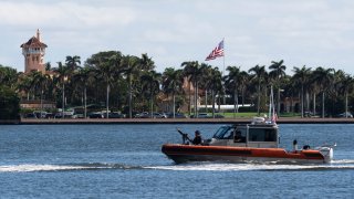 The U.S. flag is shown at the Mar-a-Lago compound in Palm Beach, Fla., while a U.S. Coast Guard boat patrols around the vicinity, Monday, Jan. 13, 2025. U.S. flags at President-elect Donald Trump's private Mar-a-Lago club are back to flying at full height. Flags are supposed to fly at half-staff through the end of January out of respect for former President Jimmy Carter, who died Dec. 29.