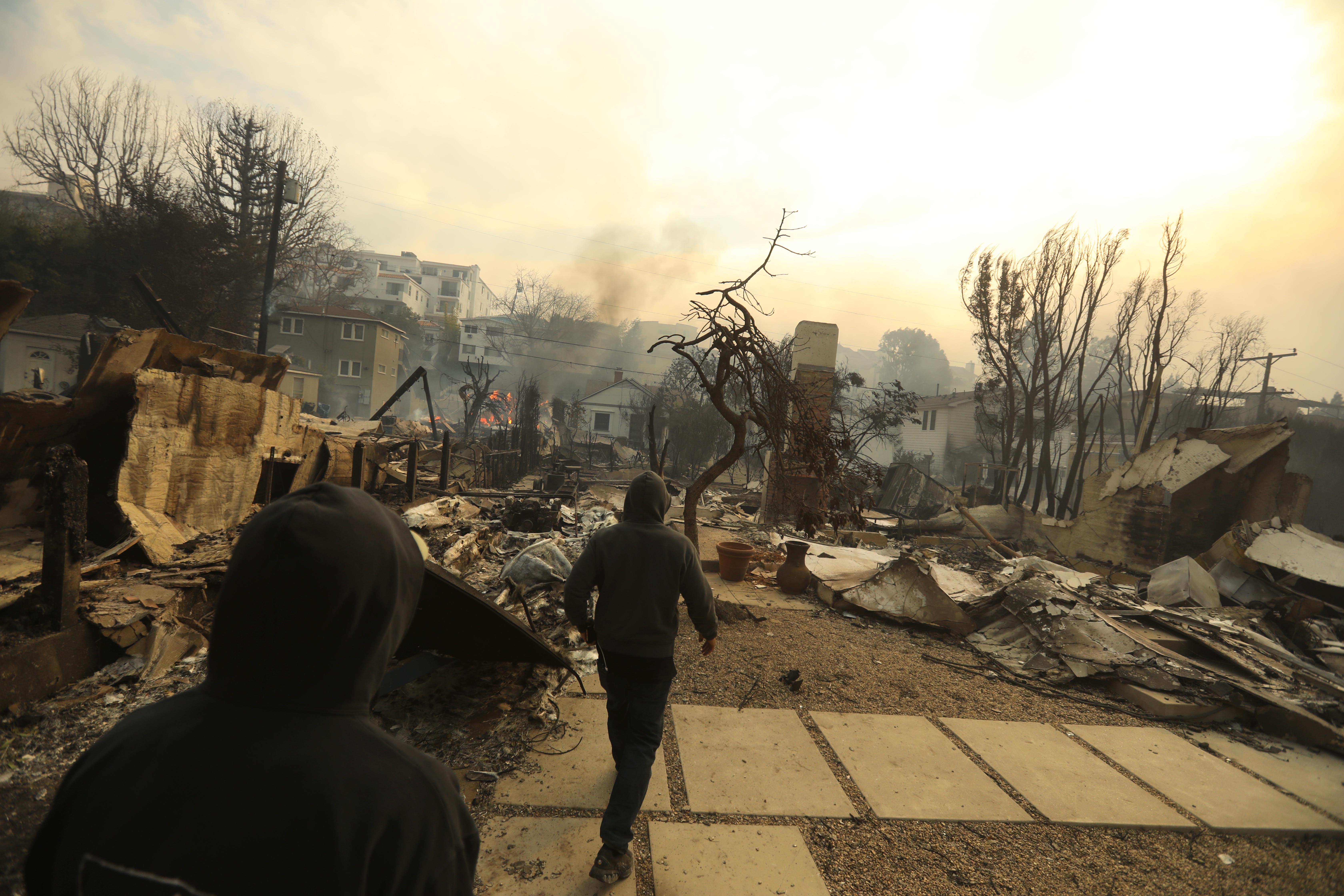 Brothers Glenn Watson, left, and his brother Wes, return to their Pacific Palisades neighborhood to view the damage from the Palisades fire on Jan. 7, 2025.