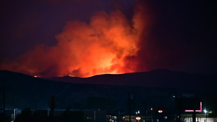 Red glowing smoke from the flames of the Hughes Fire is seen in Castaic, northwest Los Angeles County, California, on January 22, 2025. A new wildfire erupted north of Los Angeles on January 22, exploding in size and sparking thousands of evacuation orders in a region already staggering from the effects of huge blazes.