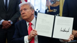 U.S. President Donald Trump holds an executive order in the Oval Office, at the White House in Washington, D.C., U.S. Feb. 25, 2025.