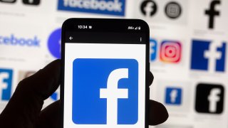 The Facebook logo is seen on a cell phone
