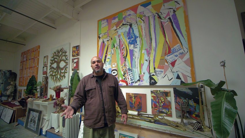 Alistair Monroe stands in front of a painting by his late father Arthur Monroe, in the Cannery Building in East Oakland.