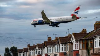 British Airways Boeing 787-8 Dreamliner aircraft spotted flying on final approach over the roofs of the houses of Myrtle avenue for landing at London Heathrow Airport LHR in the UK.