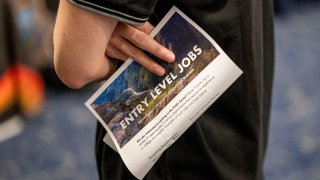 An attendee holds an “Entry Level Jobs” flyer at a City Career Fair hiring event in Sacramento, California, on Feb. 27, 2025.