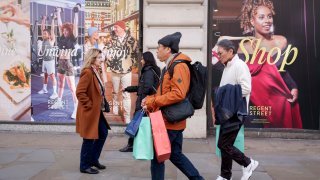 Shoppers walk past temporary billboards for the Regent Street retail business community, on Feb. 25, 2025, in London, England.
