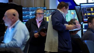 Traders work on the floor at the New York Stock Exchange on March 21, 2025.