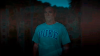 Jason Isaacs’ character Tim Ratliff wearing a Duke T-shirt