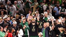 Jun 17, 2024; Boston, Massachusetts, USA; Boston Celtics forward Jayson Tatum (0) holds up the Larry O'Brien Championship Trophy after the Celtics beat the Dallas Mavericks in game five of the 2024 NBA Finals at the TD Garden. Mandatory Credit: Brian Fluharty-USA TODAY Sports