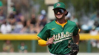 Mar 17, 2025; Mesa, Arizona, USA; Oakland Athletics shortstop Jacob Wilson (5) laughs after making a play against the Seattle Mariners in the third inning at Hohokam Stadium. Mandatory Credit: Rick Scuteri-Imagn Images