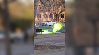 Green flames shoot out of a manhole at Texas Tech University.