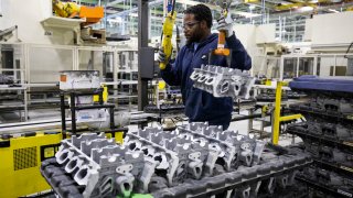 Jamell Harris loads raw casting heads to be manufactured at the Stellantis Dundee Engine Complex on August 18, 2022 in Dundee, Michigan.