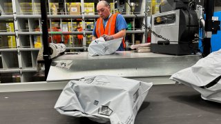 A person works at the Amazon warehouse, busy on Prime Day, in Melville, New York, July 11, 2023.