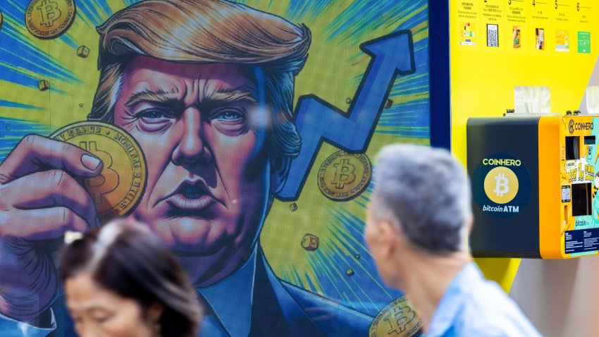 A cartoon image of US President-elect Donald Trump holding a Bitcoin token to mark the cryptocurrency reaching over $100,000 displayed at a Coinhero store in Hong Kong, China, on in Hong Kong, China, on Thursday, Dec. 5, 2024. 