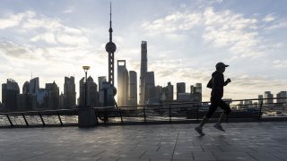 A pedestrian jogs along the Bund across from buildings in Pudong’s Lujiazui Financial District in Shanghai, China, on Thursday, Jan. 2, 2025.